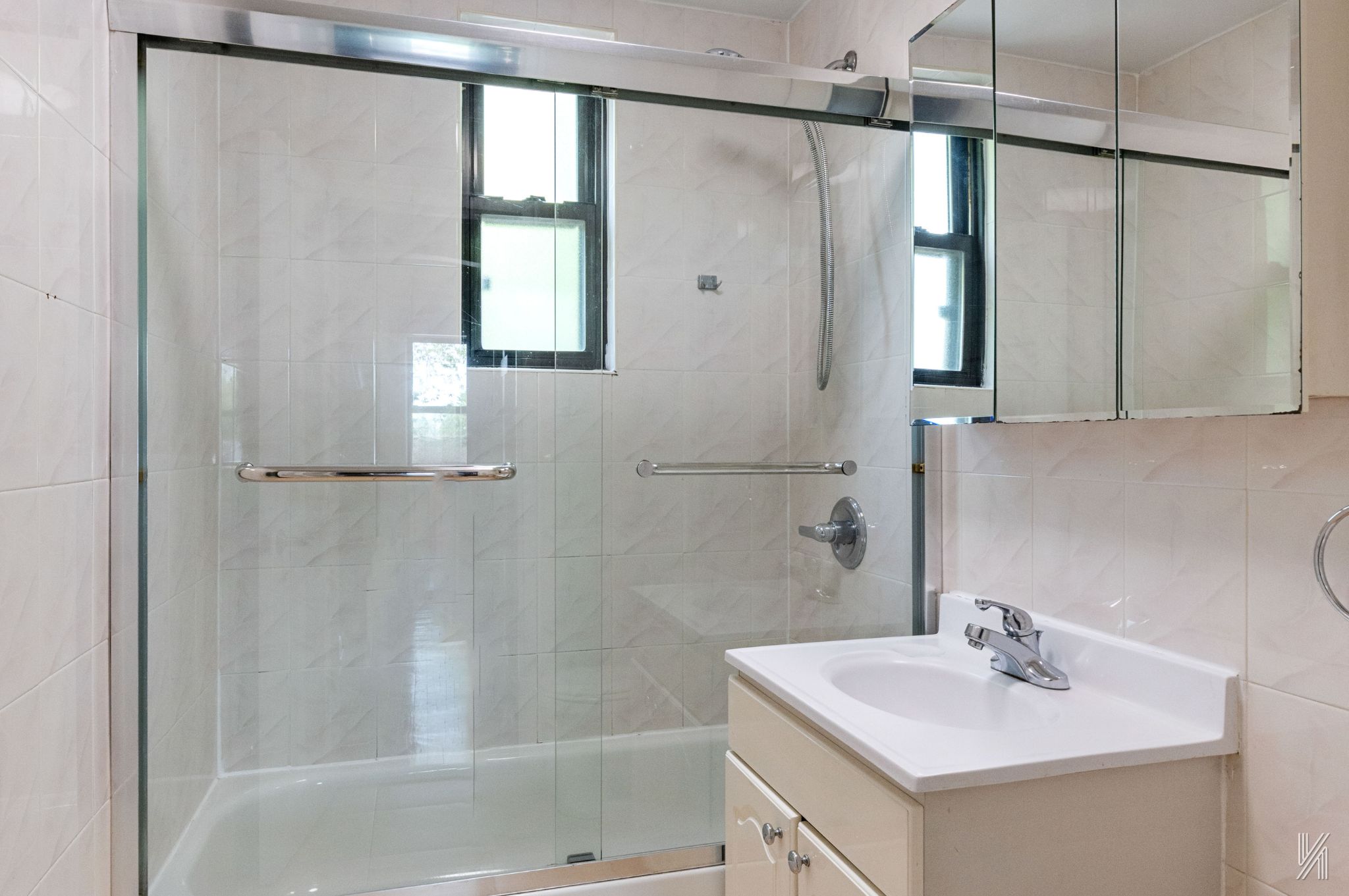 22-20 76th Street, Unit C3 Queens, NY 11370 - Photo 18 of 20 a bathroom with a sink a mirror and a shower