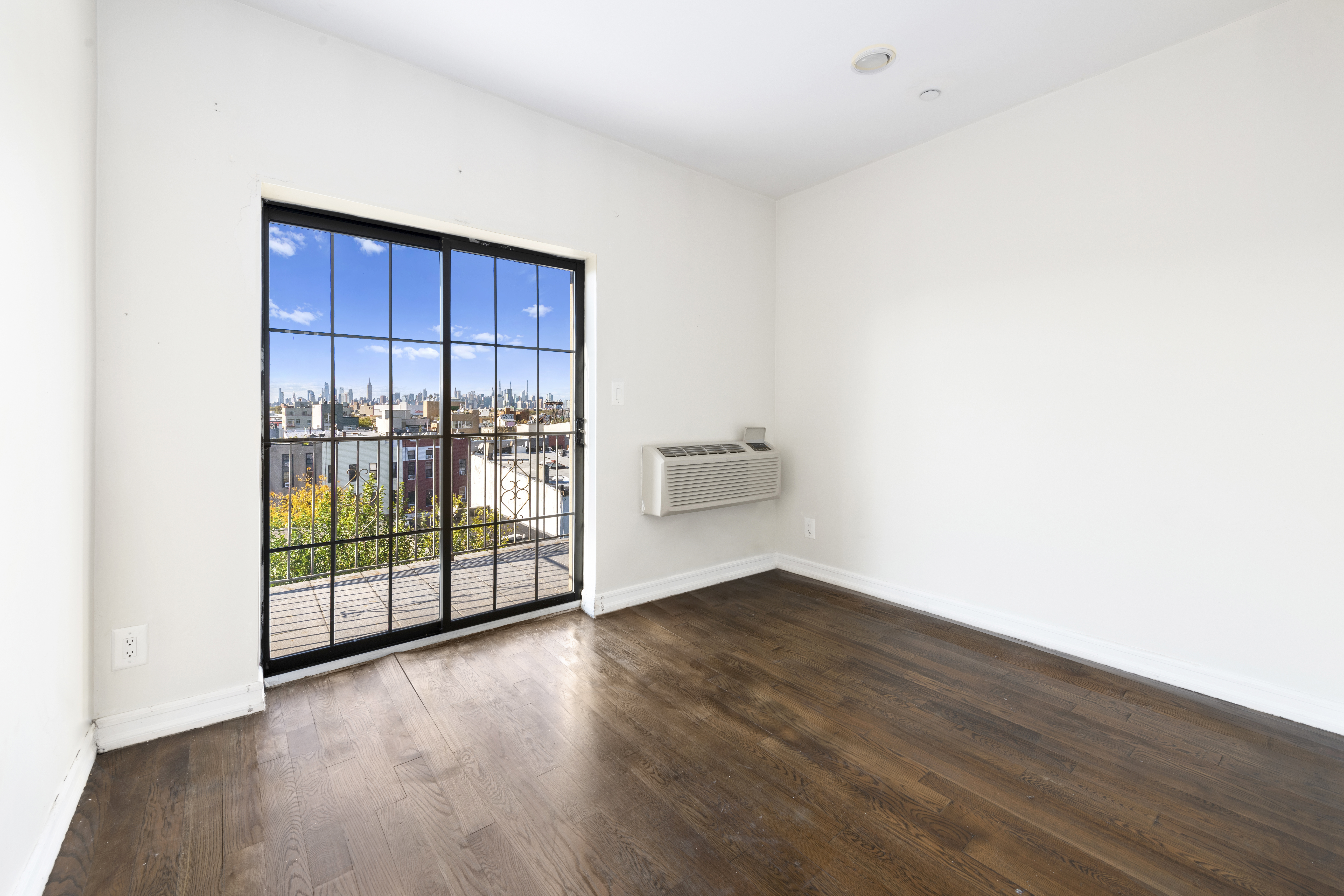 221 Troutman Street, Unit 4L Brooklyn, NY 11237 - Photo 1 of 11 a view of a room with wooden floor and sliding window