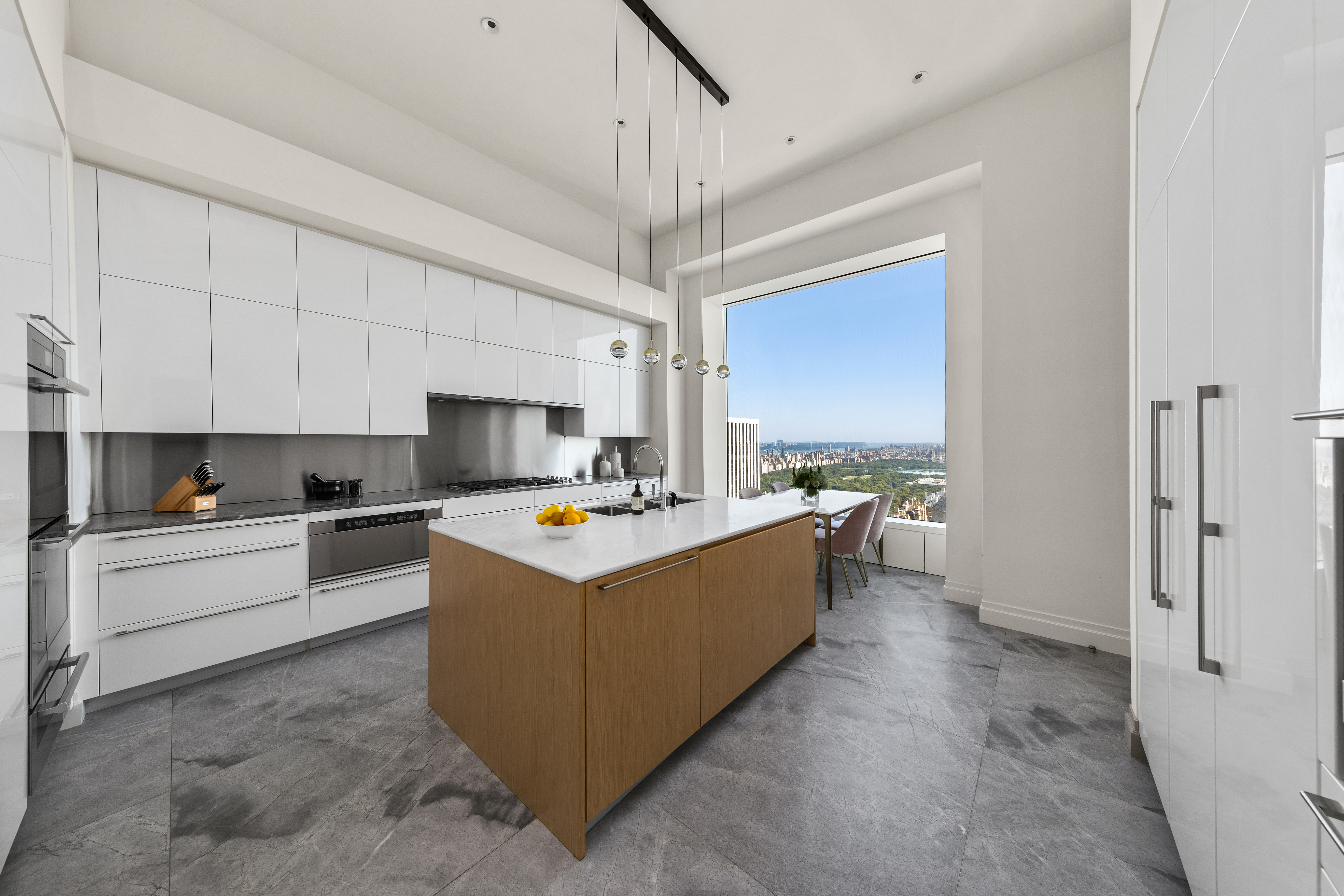 432 Park Avenue, Unit 55A Manhattan, NY 10022 - Photo 10 of 13 a large kitchen with kitchen island a sink a counter top space and cabinets