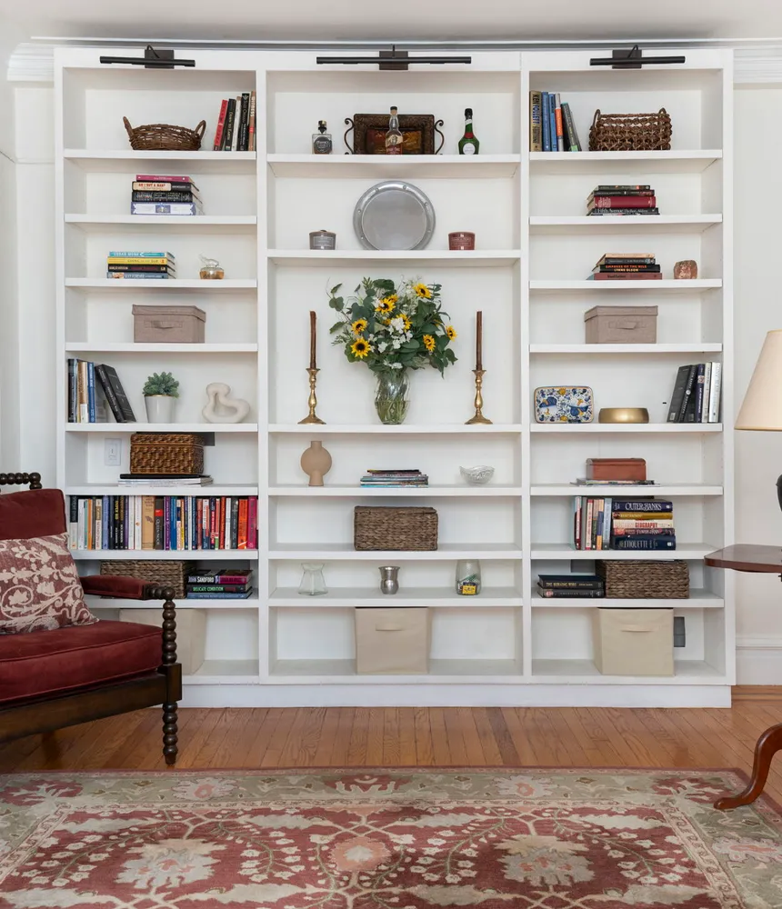 a living room with white cabinets and a book shelf