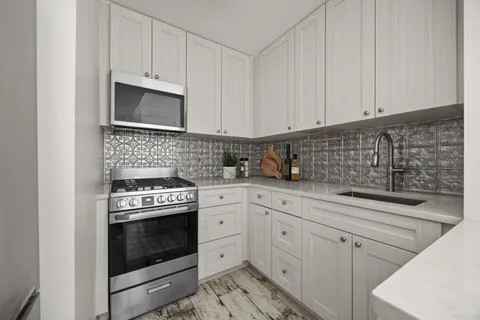 a kitchen with white cabinets and white appliances