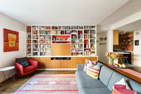 a living room with furniture and a book shelf