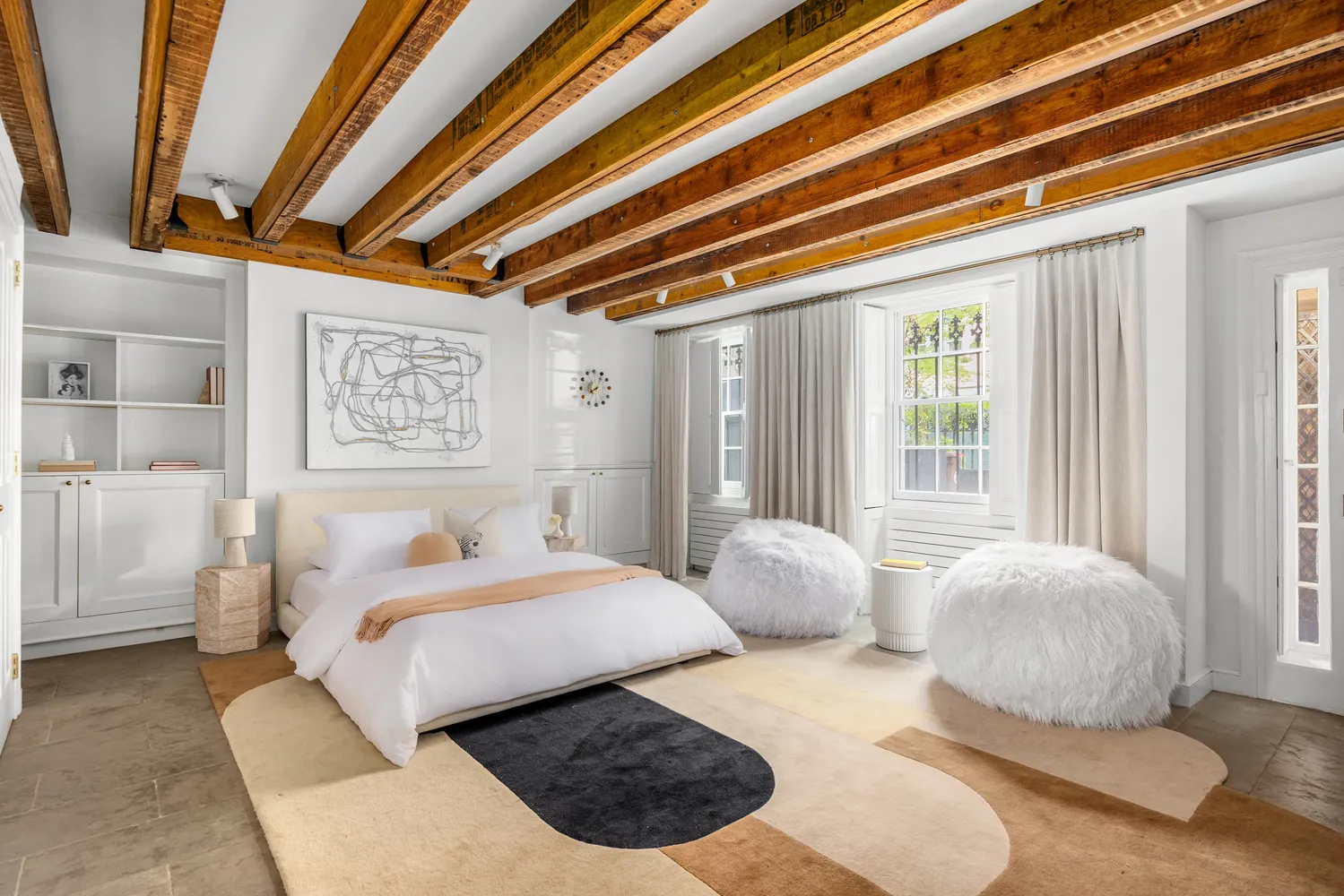 a bedroom with furniture and a large window