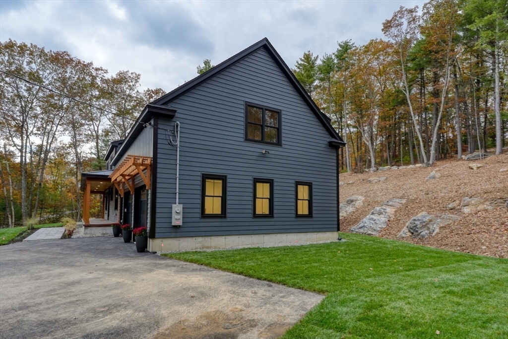 171 Randall Road Berlin, MA 01503 - Photo 34 of 41 a view of a brick house with a large windows and a yard