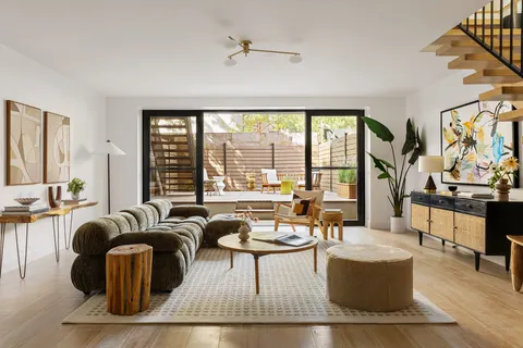 a living room with fireplace furniture and floor to ceiling windows