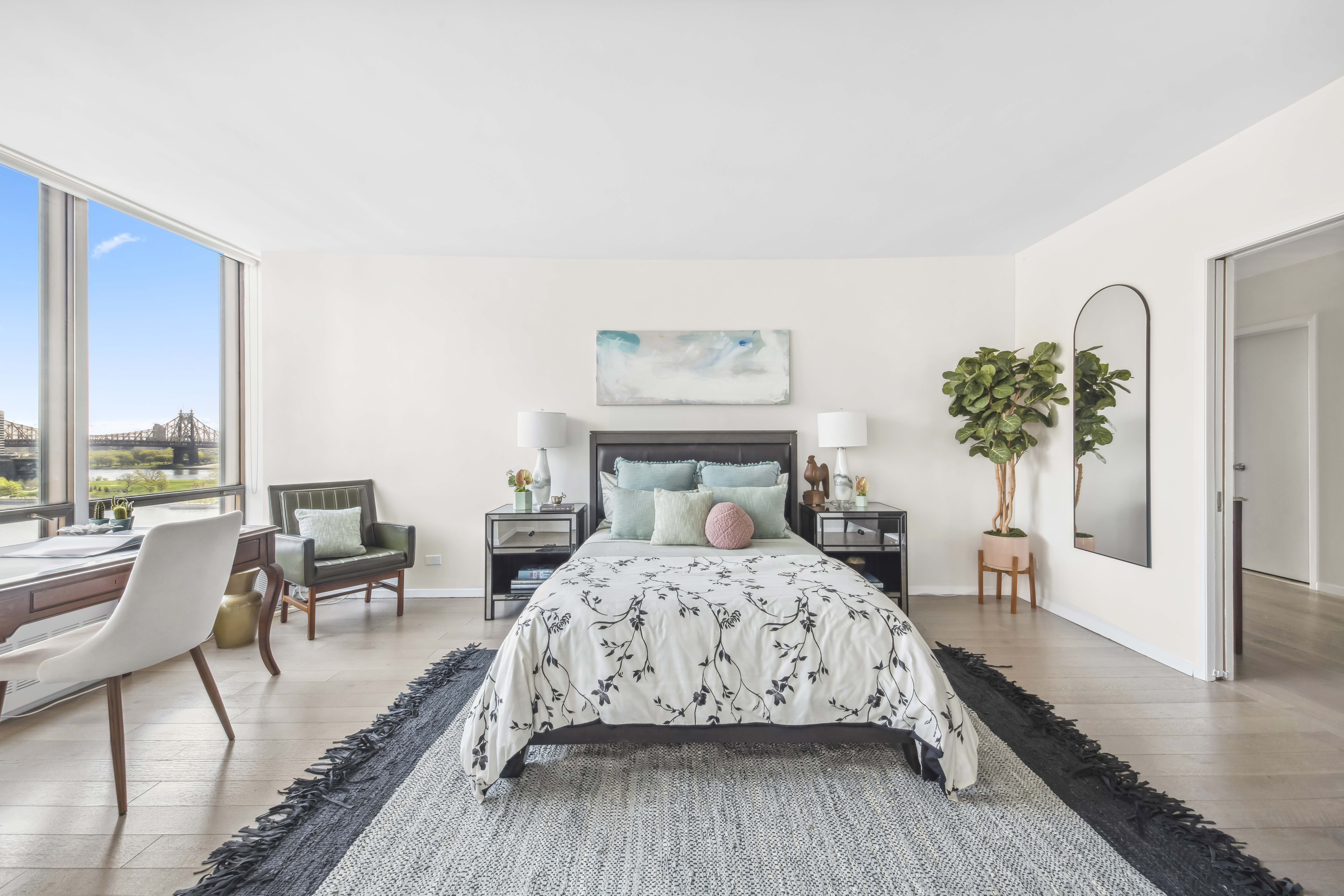 870 United Nations Plaza, Unit 15E Manhattan, NY 10017 - Photo 8 of 19 a bedroom with a bed and large windows