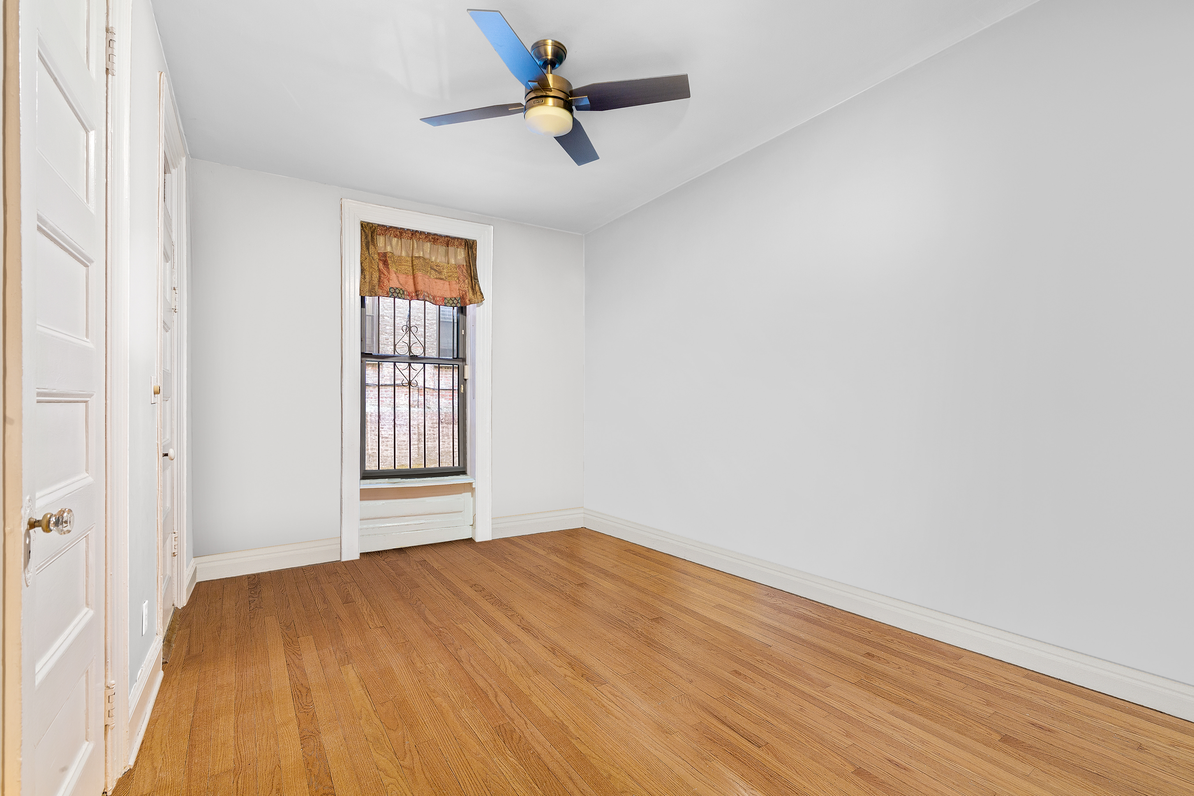 311 West 97th Street, Unit 1W Manhattan, NY 10025 - Photo 13 of 15 a view of empty room with wooden floor and fan