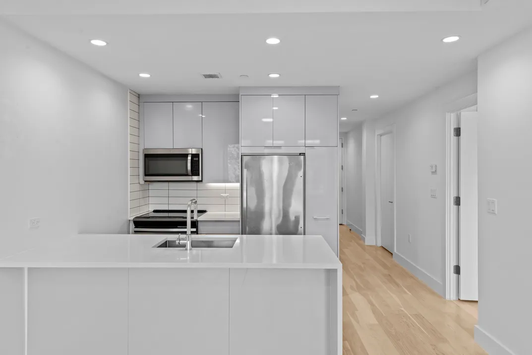 a view of kitchen with microwave and refrigerator