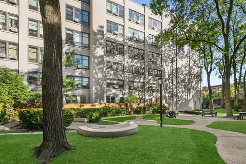 a garden with trees in front of the house