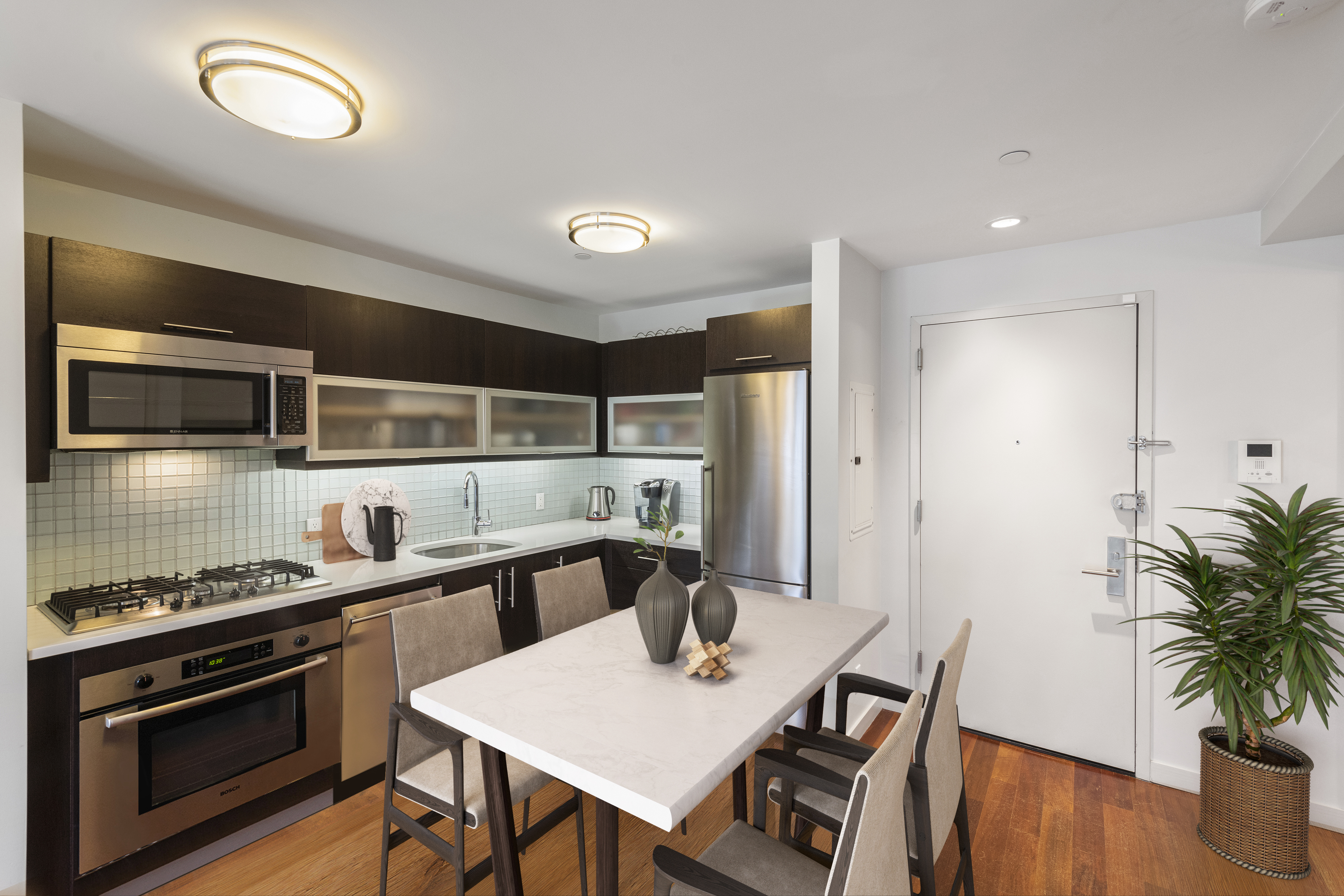 185 13th Street, Unit 2B Brooklyn, NY 11215 - Photo 4 of 8 a kitchen with stainless steel appliances a table chairs in it and wooden floors
