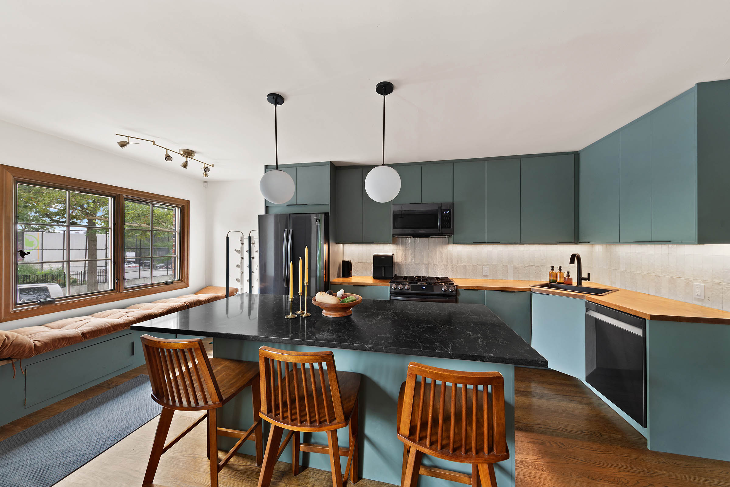 209 Onderdonk Avenue Queens, NY 11385 - Photo 2 of 16 a kitchen with stainless steel appliances granite countertop a sink a stove a dining table chairs and view living room