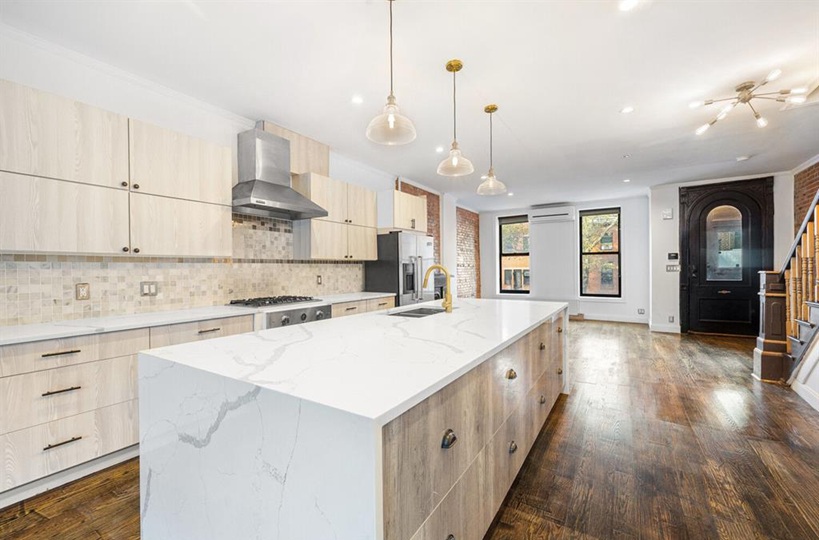 a large kitchen with kitchen island a stove a sink a center island and wooden floor