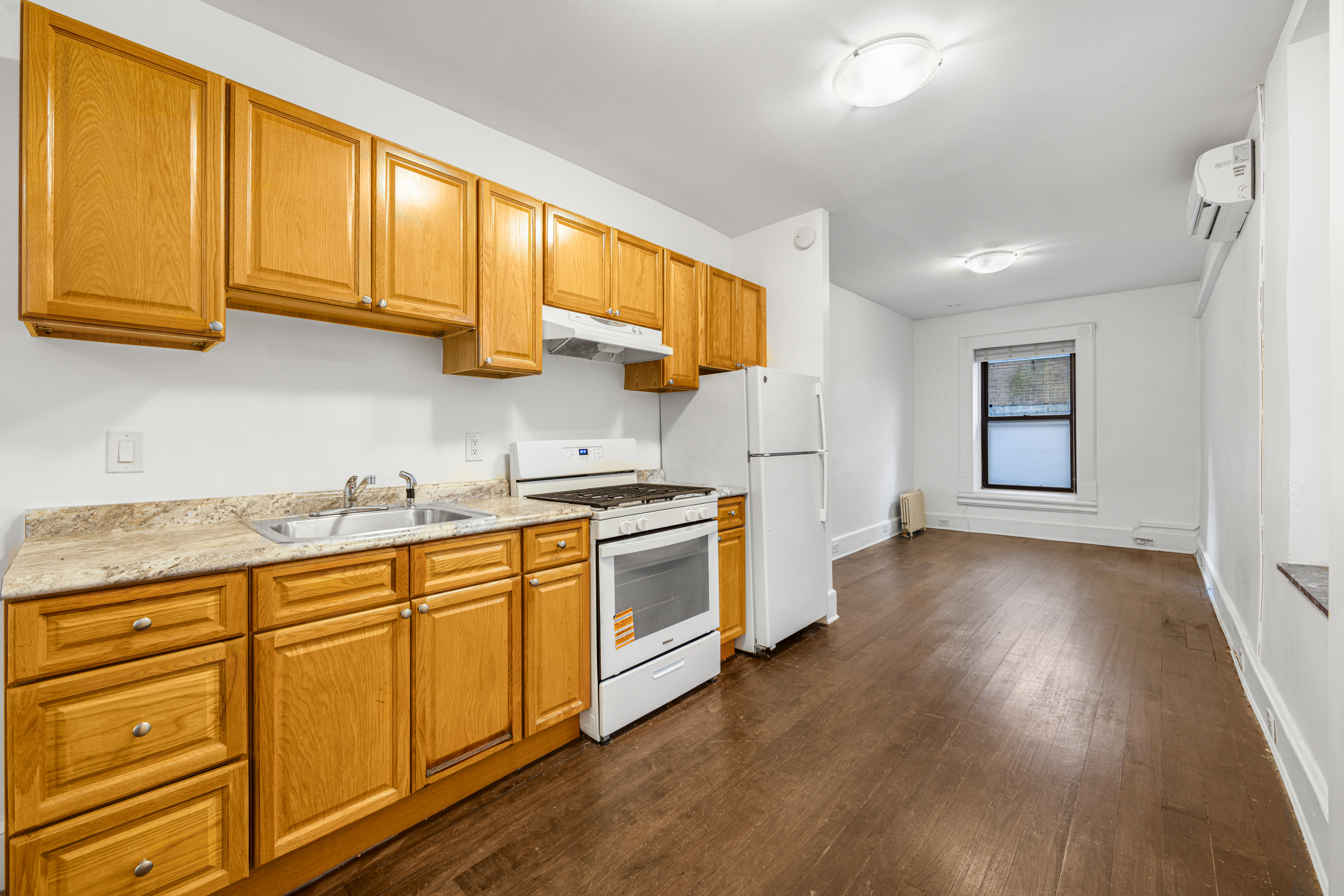 241 Mulberry Street, Unit 3 Manhattan, NY 10012 - Photo 3 of 8 a kitchen with stainless steel appliances granite countertop a stove a sink and white cabinets with wooden floors