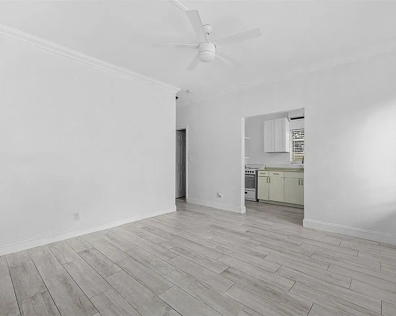 2822 Pine Tree Drive Miami Beach, FL 33140 - Photo 12 of 21 a view of a room with wooden floor and a ceiling fan