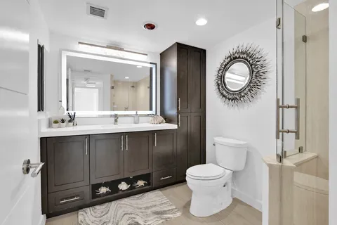 a bathroom with a toilet a sink and mirror