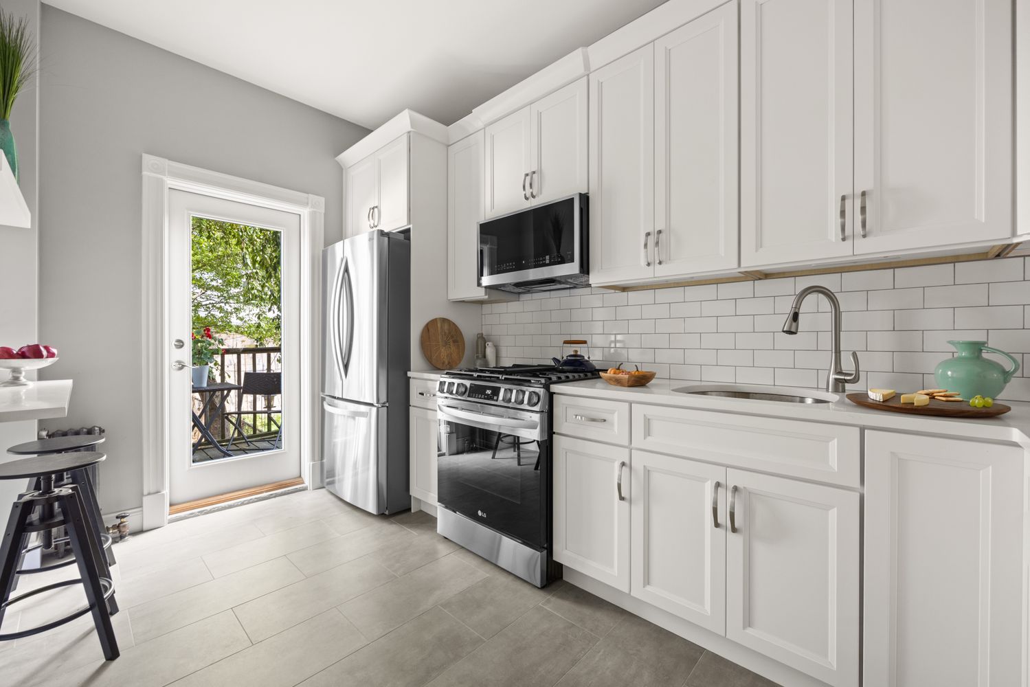 99 East 2nd Street, Unit 1 Brooklyn, NY 11218 - Photo 3 of 7 a kitchen with white cabinets and stainless steel appliances