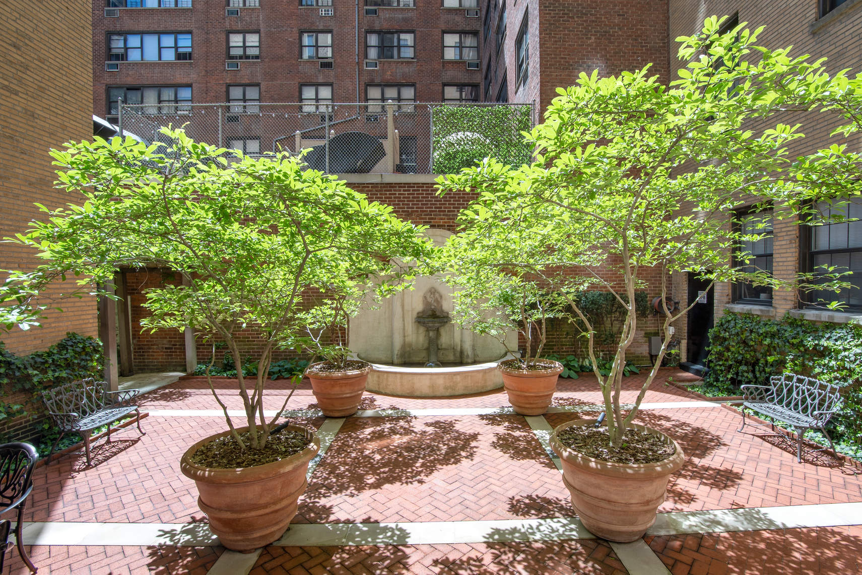 1349 Lexington Avenue, Unit PH2 Manhattan, NY 10128 - Photo 14 of 18 a view of a backyard with table and chairs potted plants and large tree