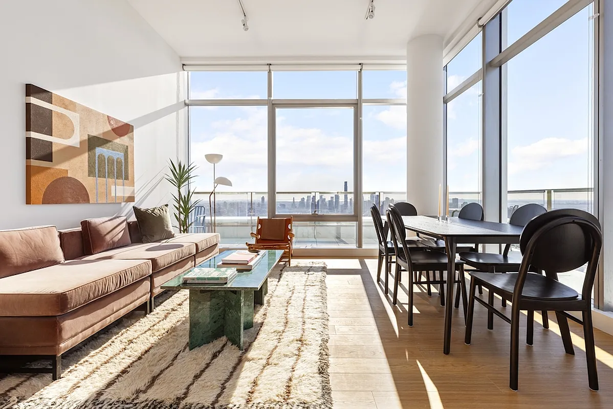 a living room with furniture and large windows