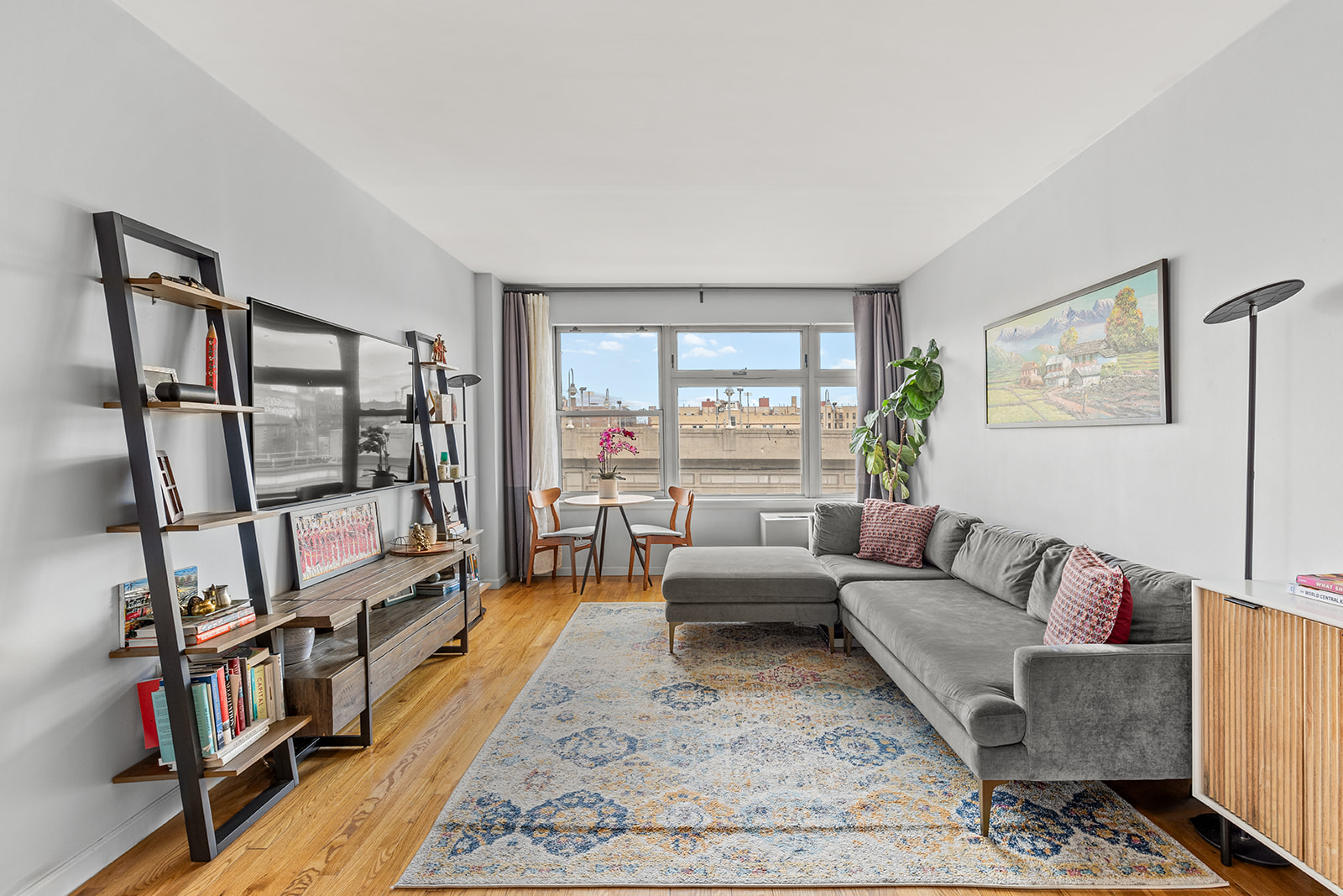 a living room with furniture a rug and a book shelf