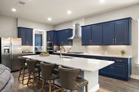 a kitchen with a table chairs refrigerator and cabinets