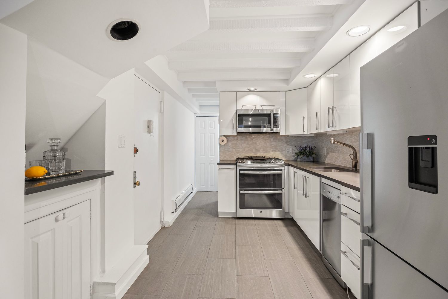261 West 71st Street, Unit 1 Manhattan, NY 10023 - Photo 7 of 15 a kitchen with granite countertop a sink stove and refrigerator