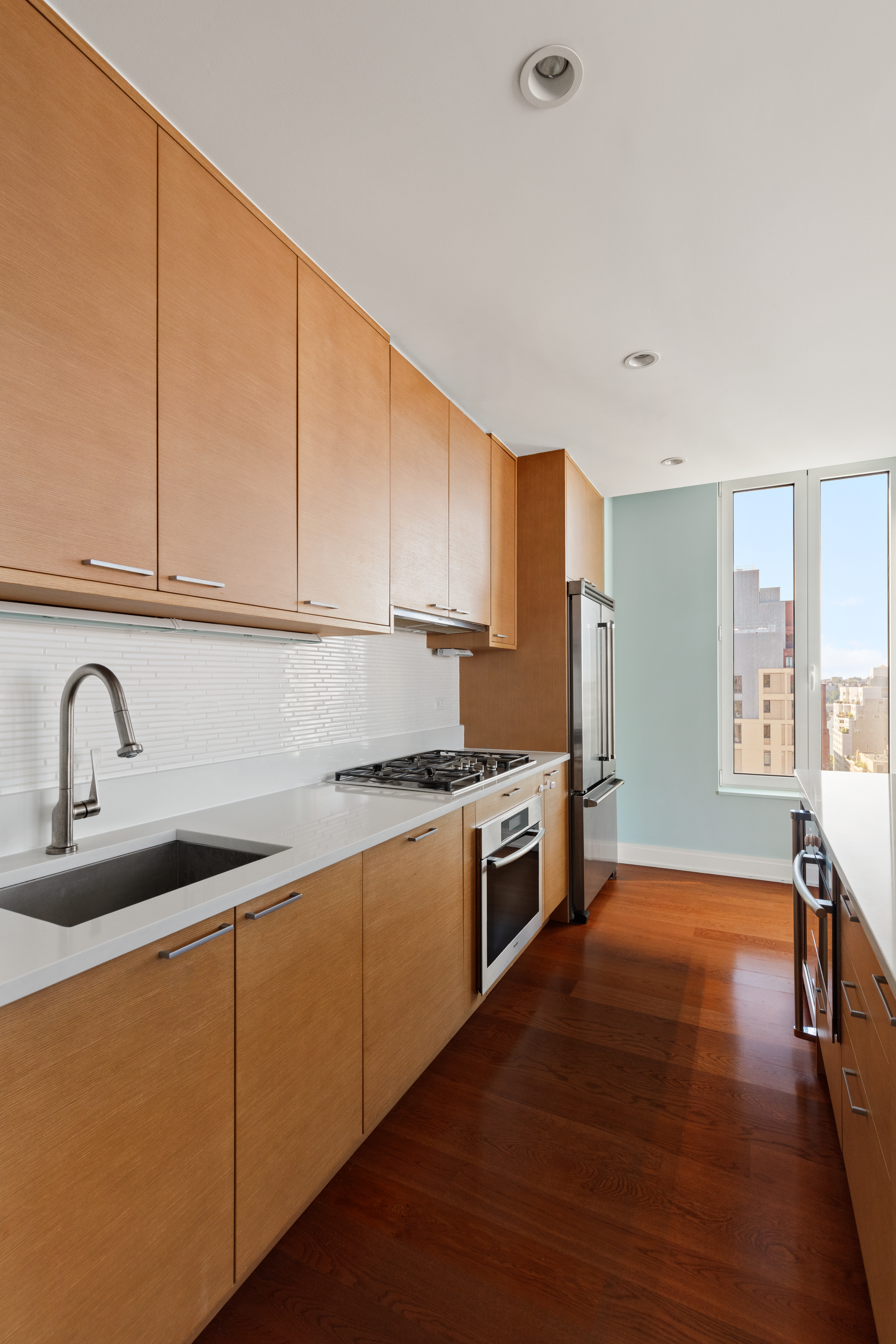 230 West 78th Street, Unit 18A Manhattan, NY 10024 - Photo 4 of 14 a kitchen with stainless steel appliances granite countertop a sink a stove a refrigerator with wooden cabinets and floors