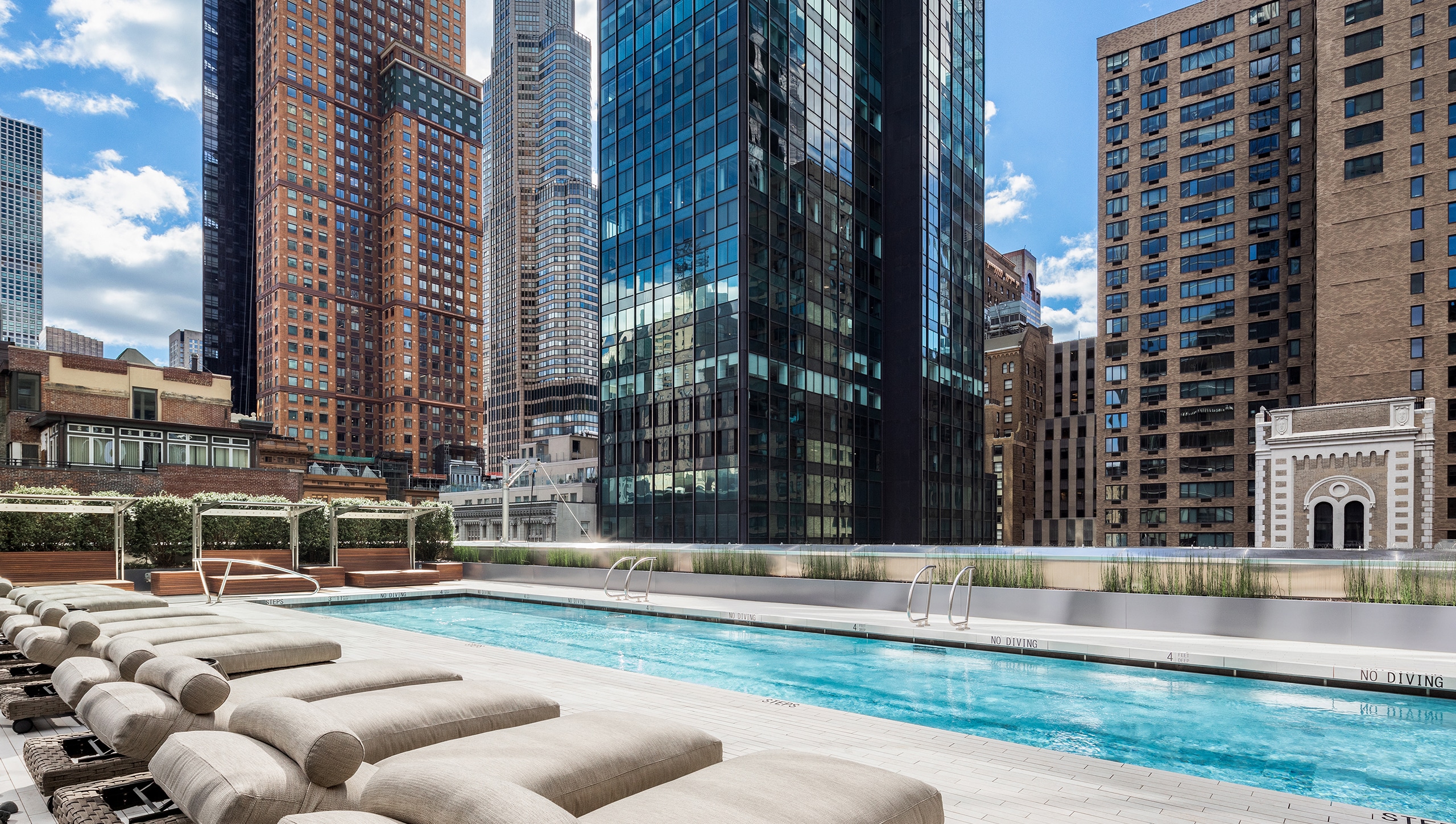 217 West 57th Street, Unit 60W Manhattan, NY 10019 - Photo 22 of 27 a view of building with swimming pool and sitting area