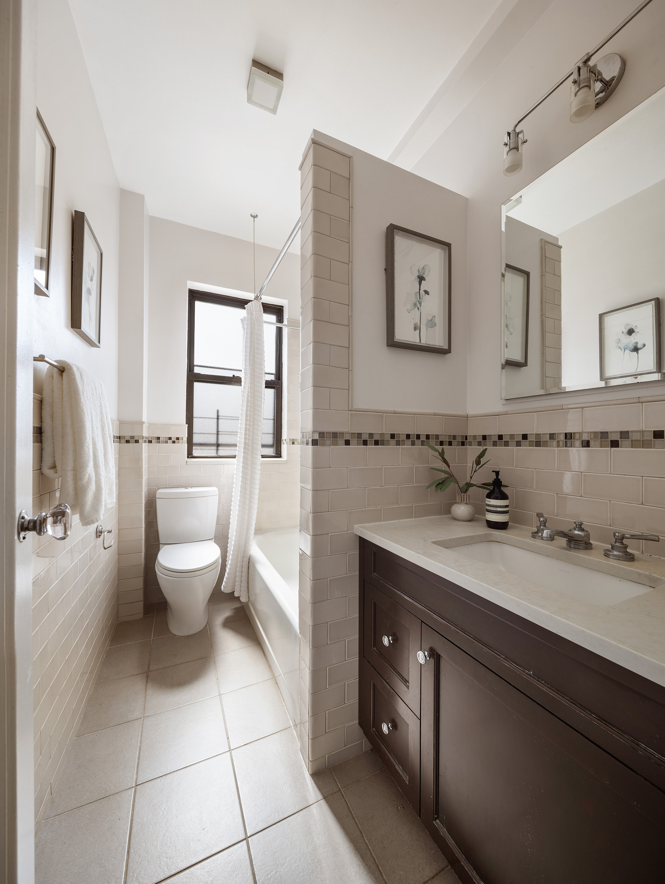 215 West 92nd Street, Unit 10F Manhattan, NY 10025 - Photo 7 of 11 a spacious bathroom with a toilet sink and mirror