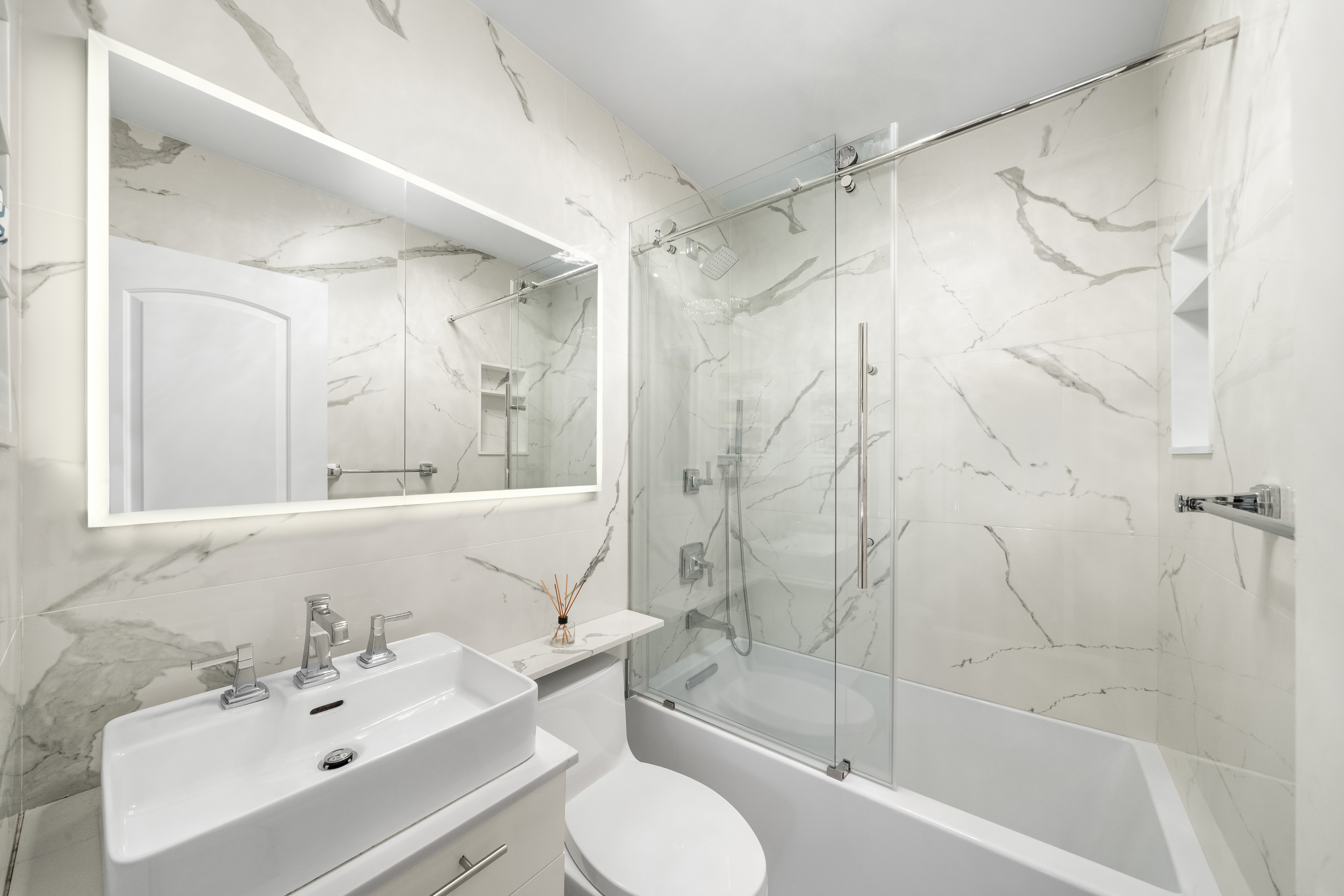 24 5th Avenue, Unit 1212 Manhattan, NY 10011 - Photo 4 of 9 a bathroom with a sink toilet and shower