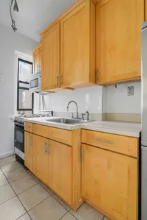 a kitchen with stainless steel appliances granite countertop a sink a stove and white cabinets