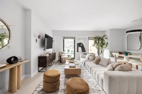 a living room with furniture a mirror and a flat screen tv