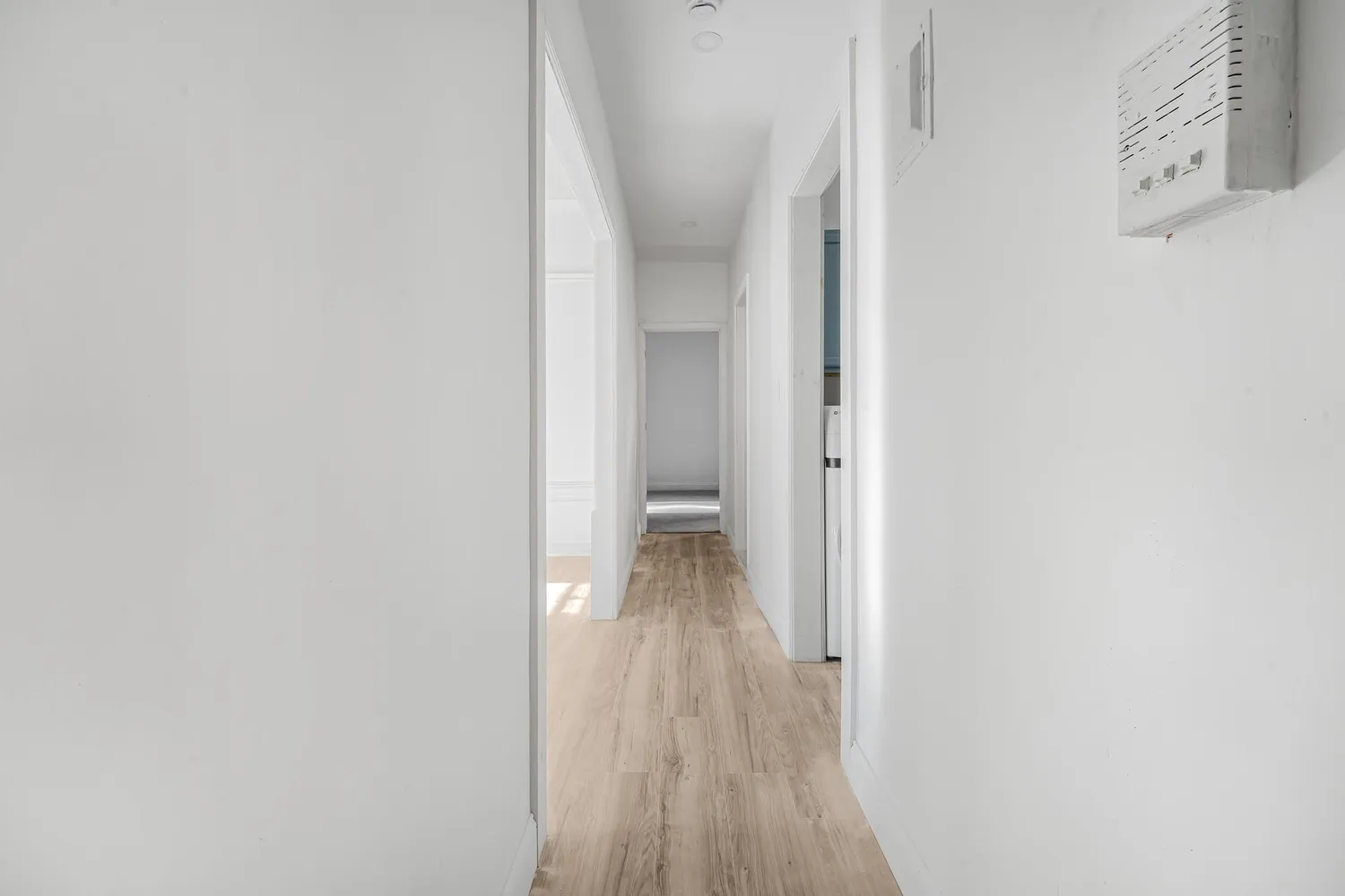 a view of a hallway with wooden floor
