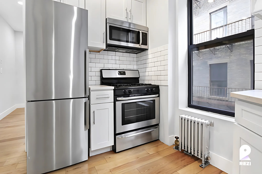 175 East 105th Street, Unit 3R Manhattan, NY 10029 - Photo 2 of 8 a kitchen with stainless steel appliances a refrigerator microwave and stove