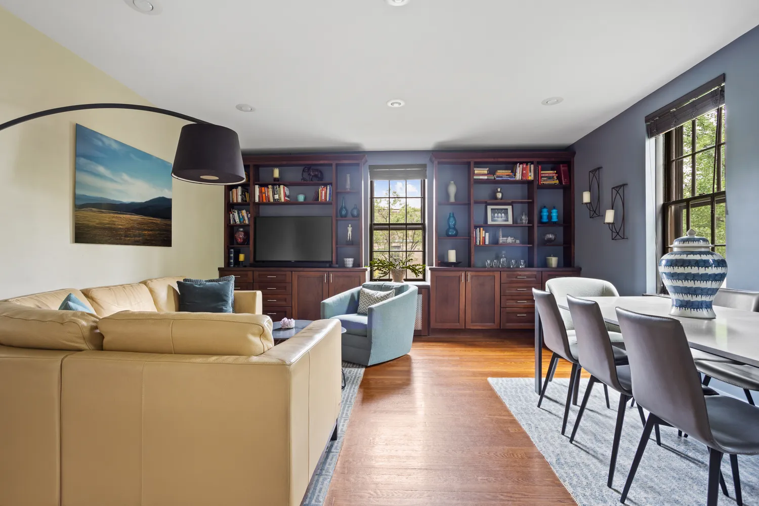 a living room with furniture a flat screen tv and bookshelf