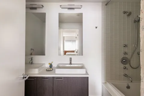 a bathroom with a double vanity sink mirror and shower