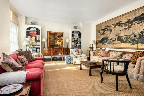 a living room with furniture and a large window with rug