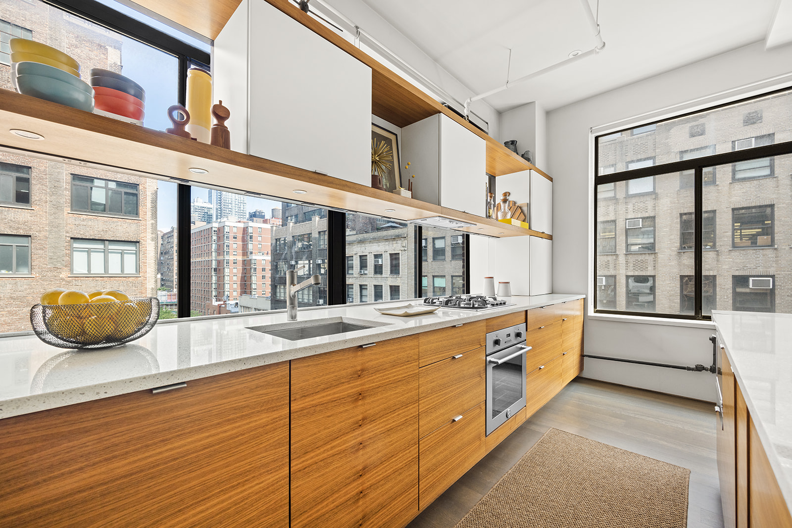 348 West 36th Street, Unit 6N Manhattan, NY 10018 - Photo 4 of 12 a large white kitchen with a large window and stainless steel appliances
