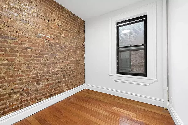 112 East 97th Street, Unit 3E Manhattan, NY 10029 - Photo 4 of 4 a view of a small space with wooden floor and a window