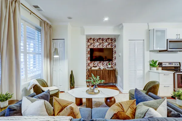 a living room with furniture a flat screen tv and a table