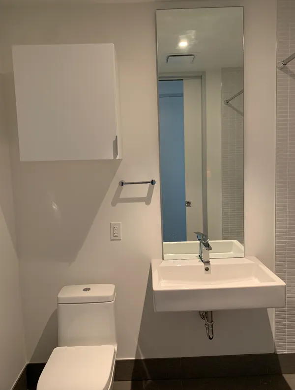 a bathroom with a sink toilet and mirror