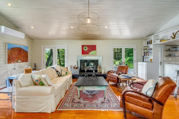 a living room with fireplace furniture and a large window