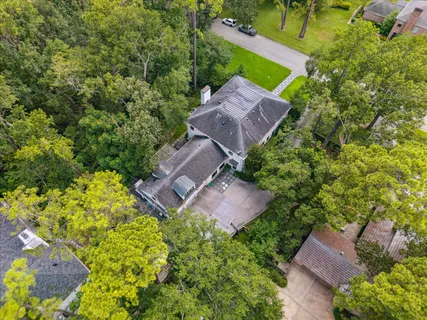 an aerial view of a house with a yard and large trees