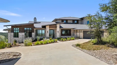 a front view of a house with a yard and potted plants