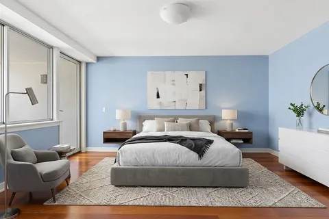 a bedroom with a large bed couch and a window
