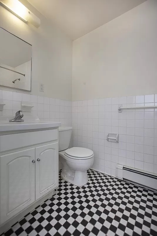 469 West 141st Street Manhattan, NY 10031 - Photo 10 of 14 a bathroom with a sink a toilet and a mirror