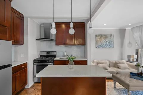 a kitchen with stainless steel appliances granite countertop a stove a sink a microwave a refrigerator and white cabinets