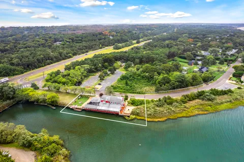 an aerial view of a house with a garden and lake view