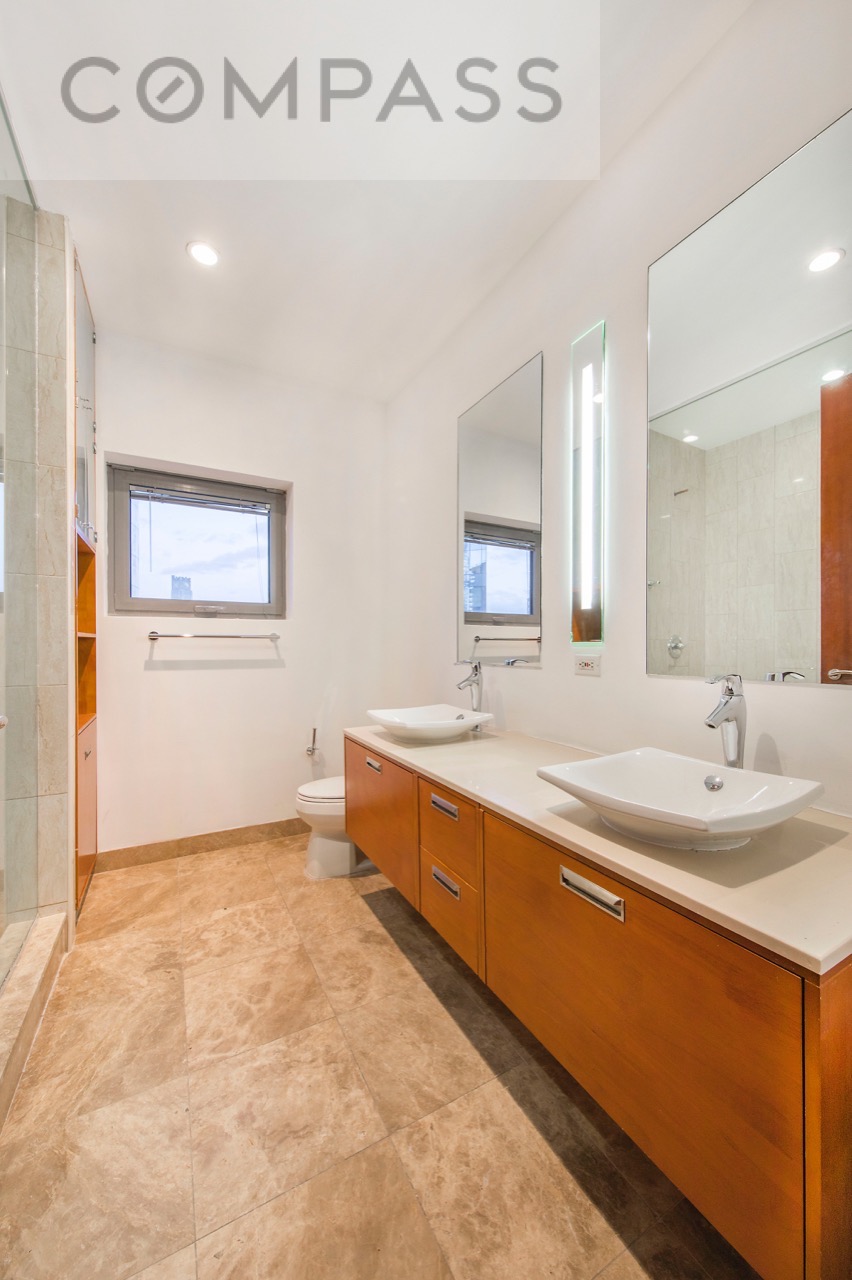 42-51 Hunter Street, Unit 3D Queens, NY 11101 - Photo 6 of 14 a large bathroom with a double vanity sink and a mirror