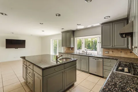 a kitchen that has a sink and a stove in it