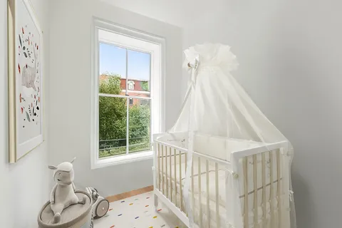 a view of a bedroom with wooden floor and a bed